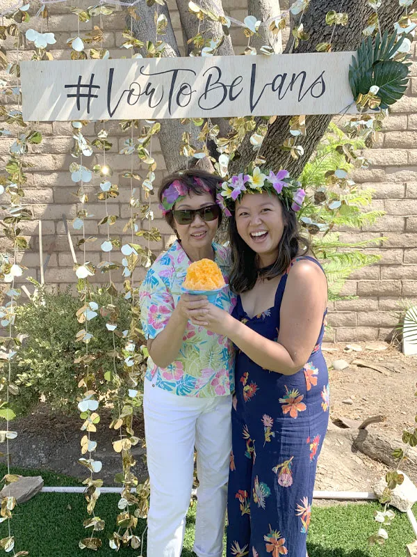 Guests in flower crowns holding shave ice at a wedding
